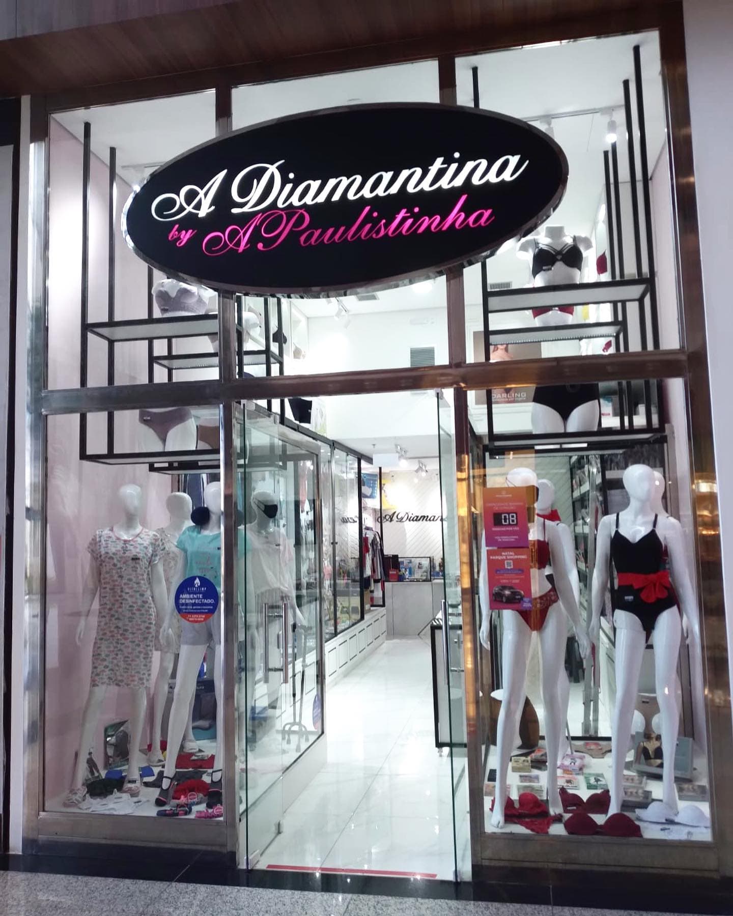 Fachada de uma loja A Diamantina, com o letreiro aceso e a vitrine montada.